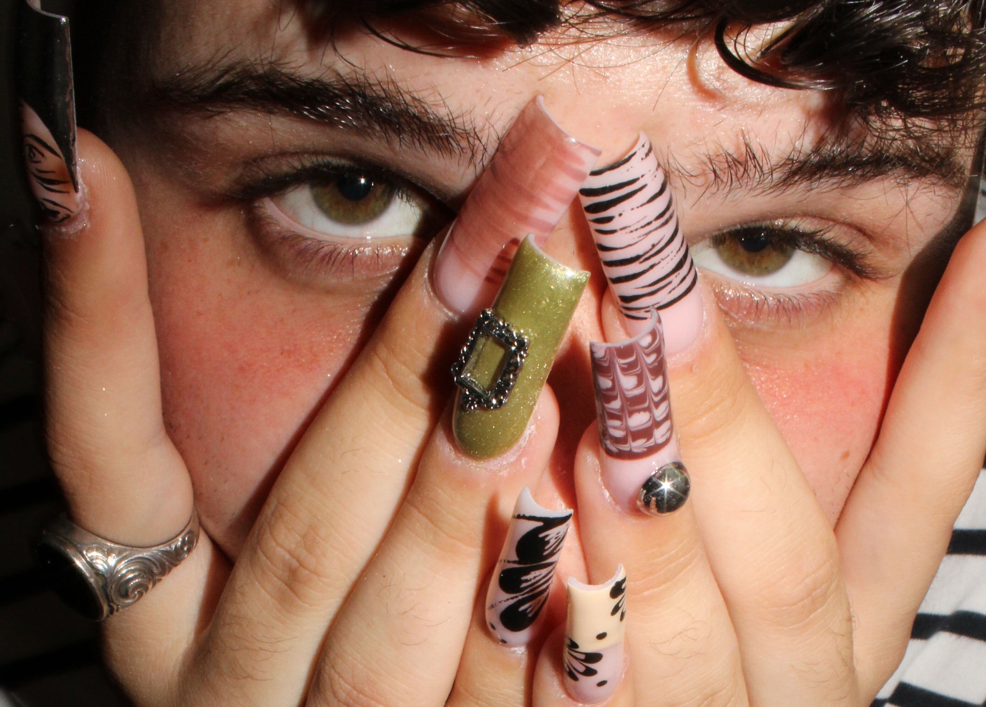 Nahaufnahme von kunstvoll verzierten Nägeln bei Babe Cosmetics in Basel, Basel-stadt, CH.