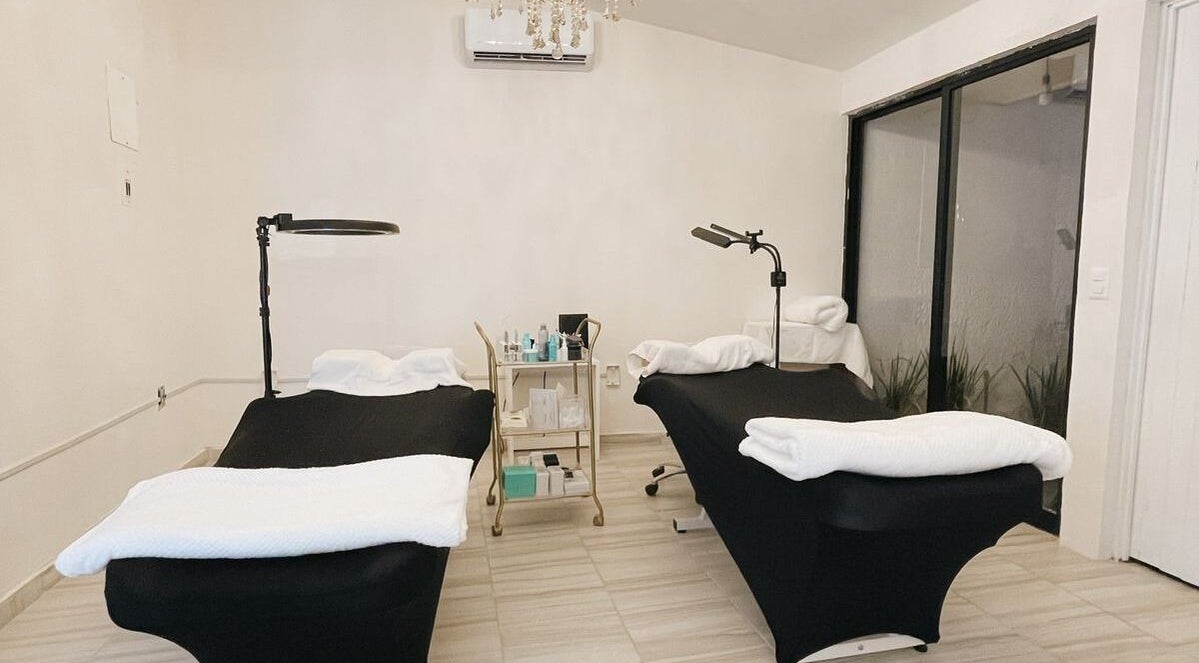 Sala de tratamiento dual en Genoveva Beauty Studio, Oaxaca De Juárez, Oaxaca, MX, con camas de masaje y luz tenue.