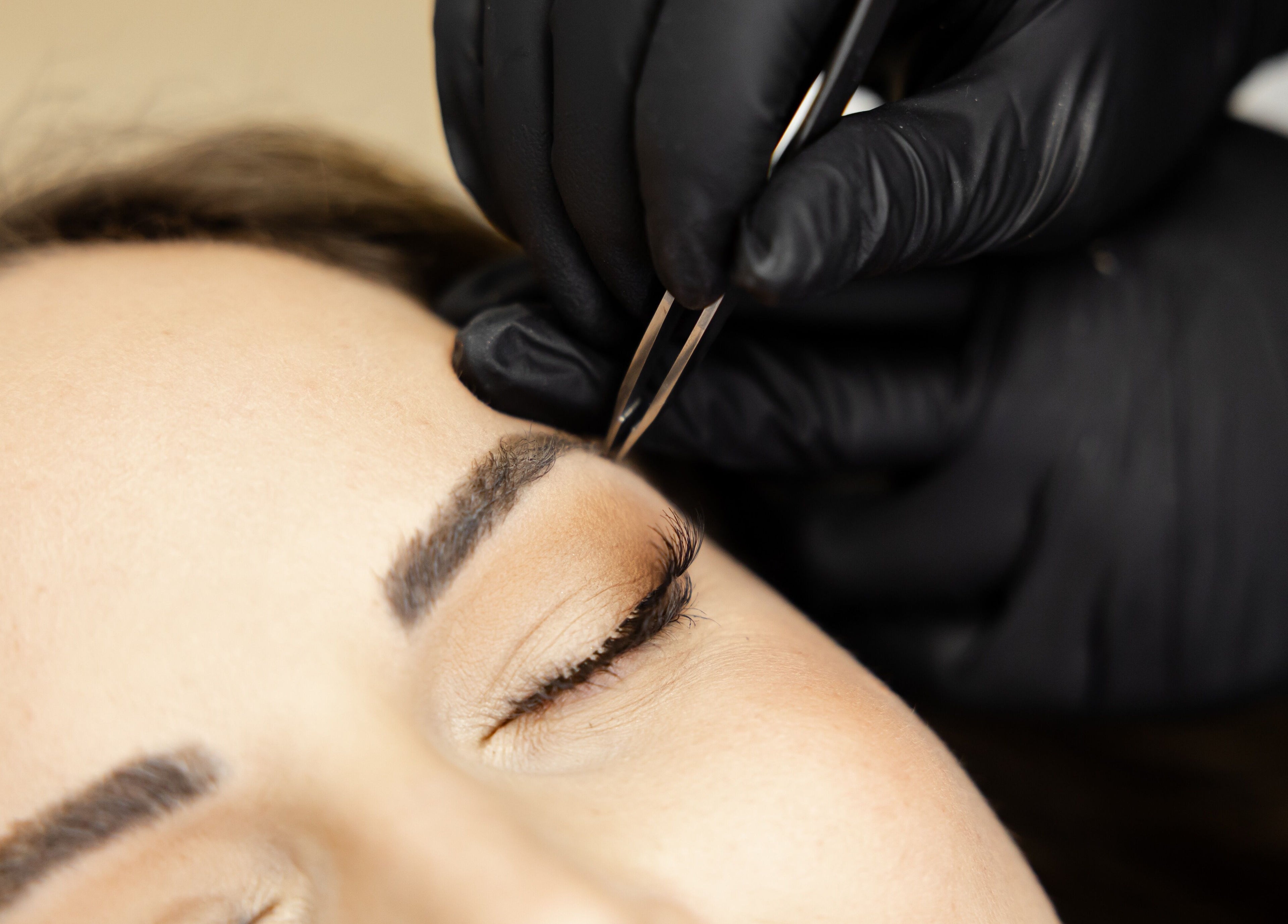 Eyebrow grooming at The Babe Cave in Hanover, Ontario, CA, showcasing a precise tweezer technique.