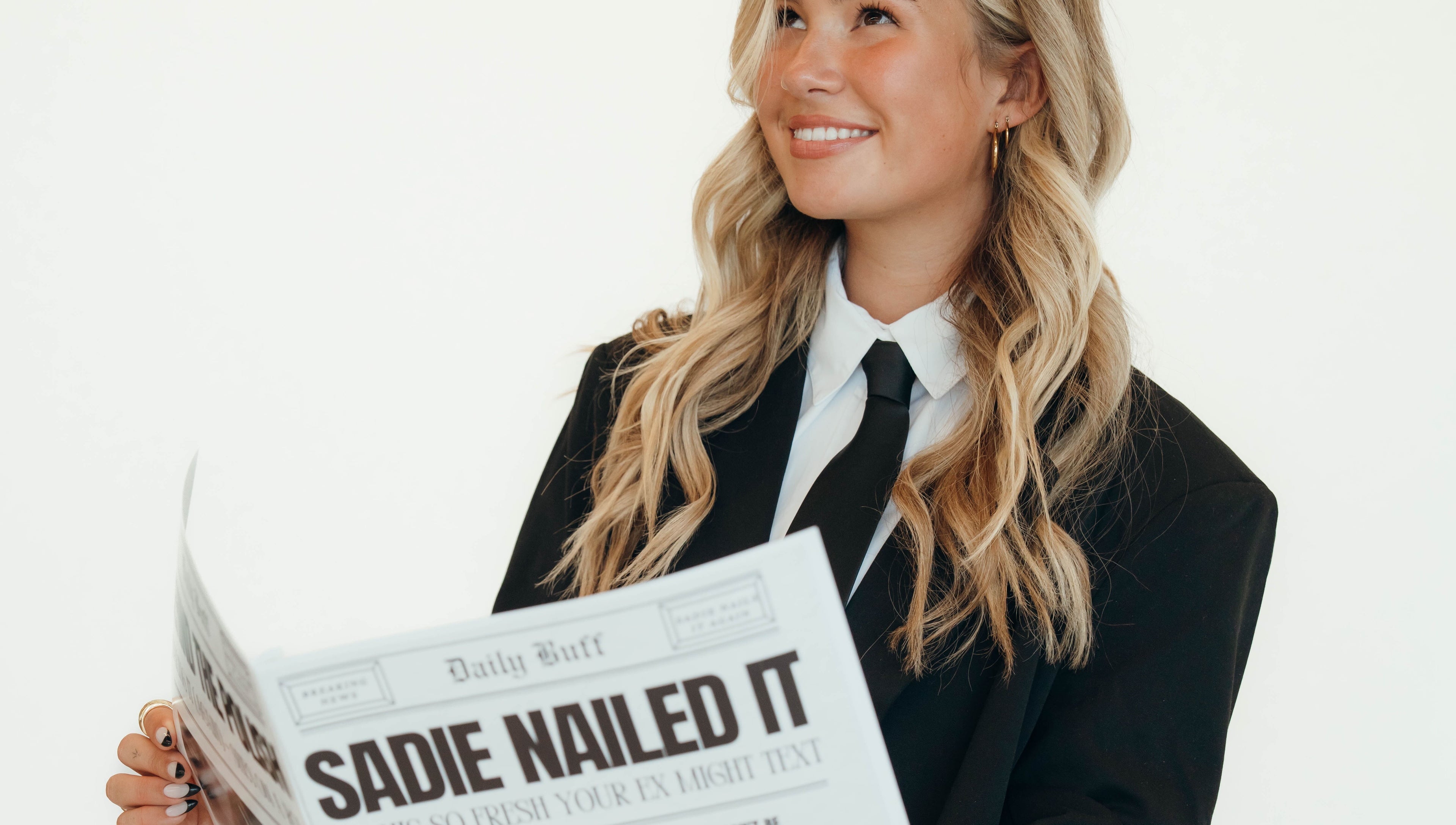 Smiling person in a suit reading newspaper at Sadie Nailed It, Pleasant Grove, Utah, US.