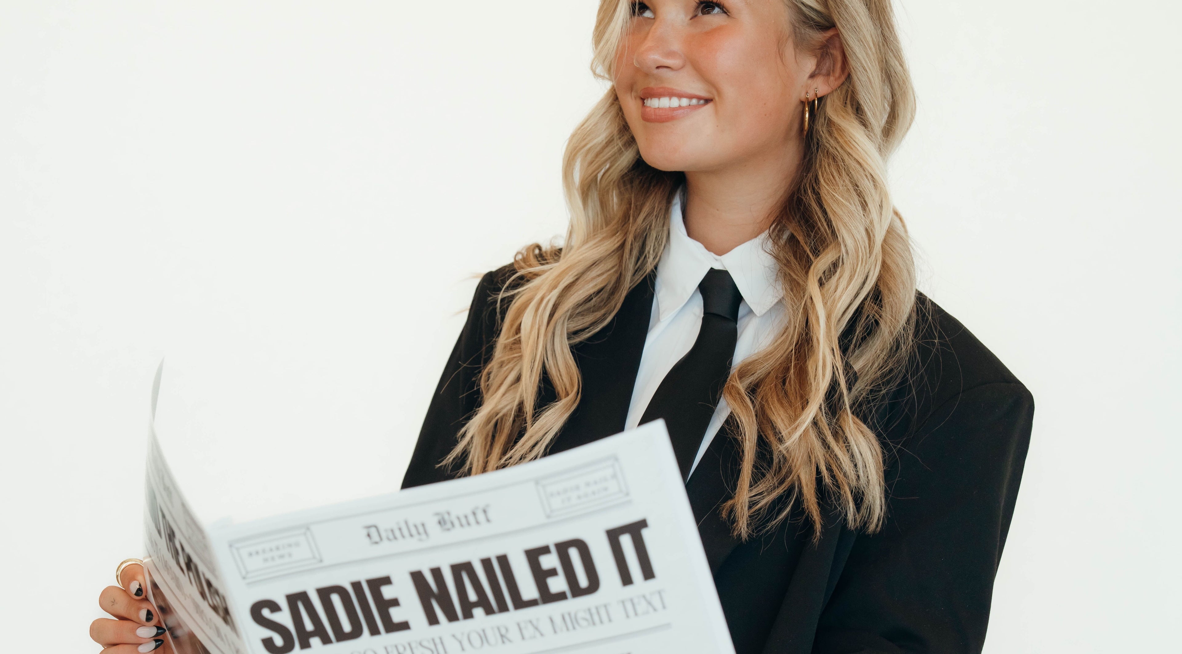 Smiling person in a suit reading newspaper at Sadie Nailed It, Pleasant Grove, Utah, US.