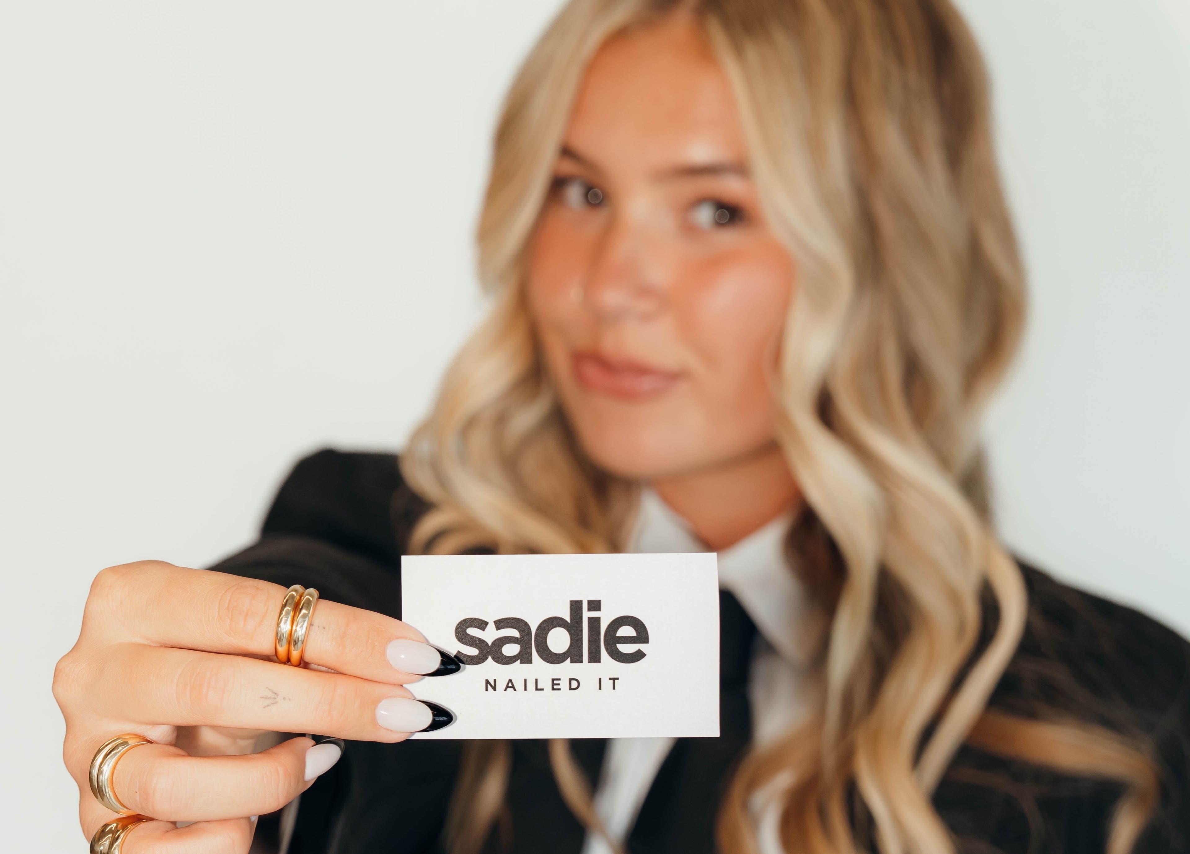 A woman holds a 'Sadie Nailed It' card in Pleasant Grove, Utah, US.