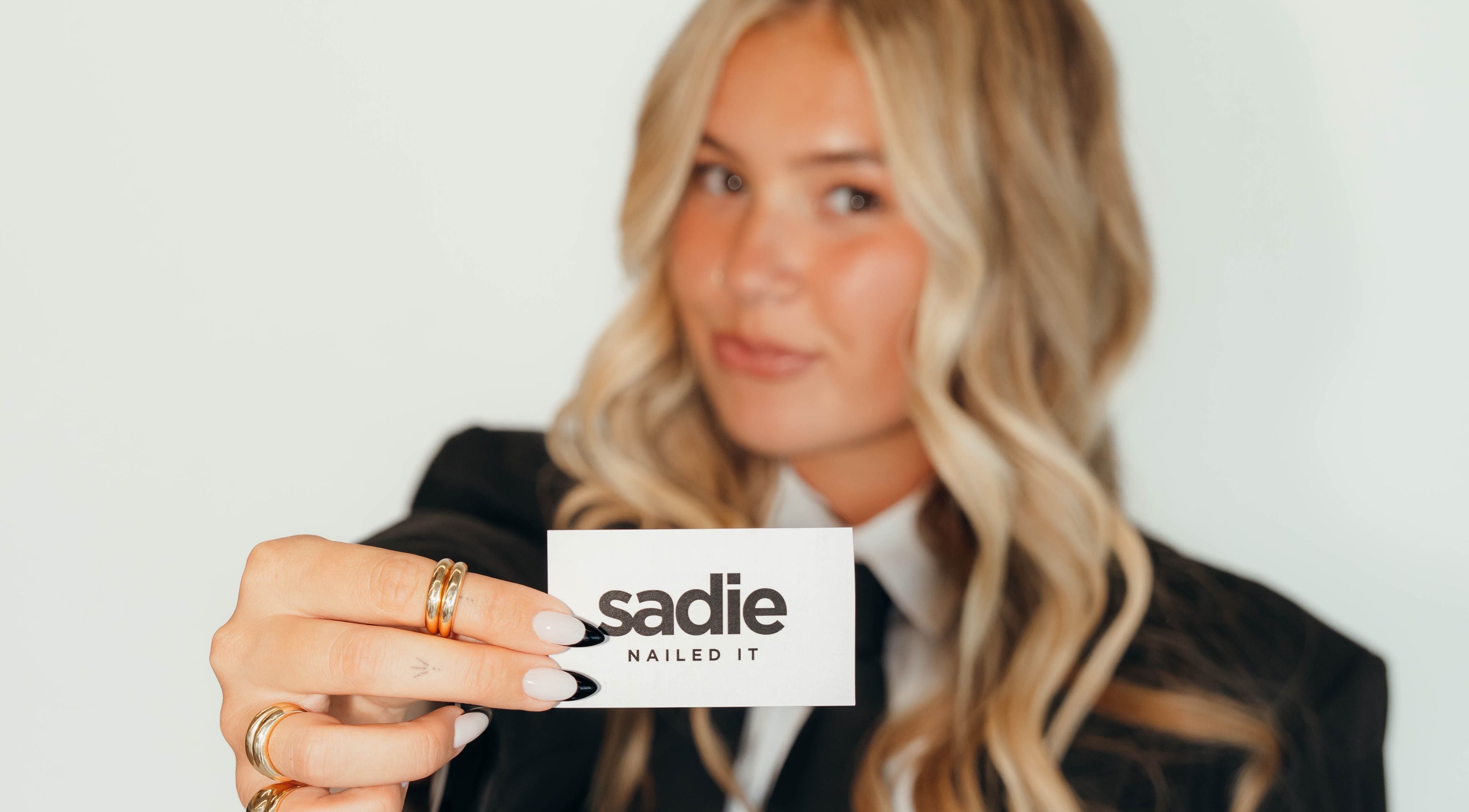 A woman holds a 'Sadie Nailed It' card in Pleasant Grove, Utah, US.