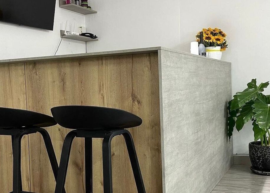 Recepción moderna en Melo Barber Studio Miraflores, Miraflores, Provincia De Lima, PE con silla y planta.