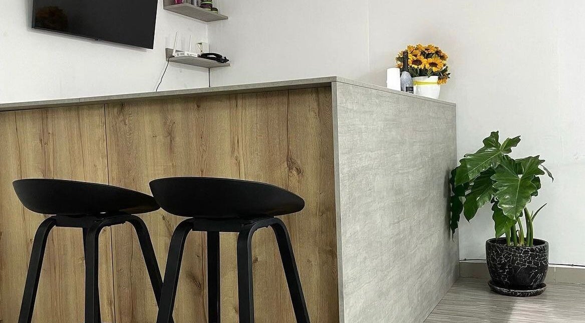 Recepción moderna en Melo Barber Studio Miraflores, Miraflores, Provincia De Lima, PE con silla y planta.