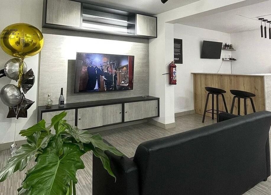 Interior moderno de Melo Barber Studio San Luis, Provincia De Lima, PE con asientos y televisor.