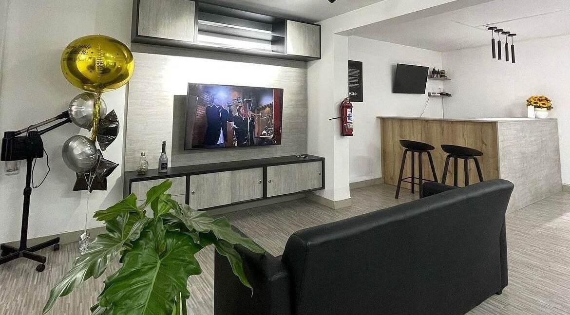 Interior moderno de Melo Barber Studio San Luis, Provincia De Lima, PE con asientos y televisor.