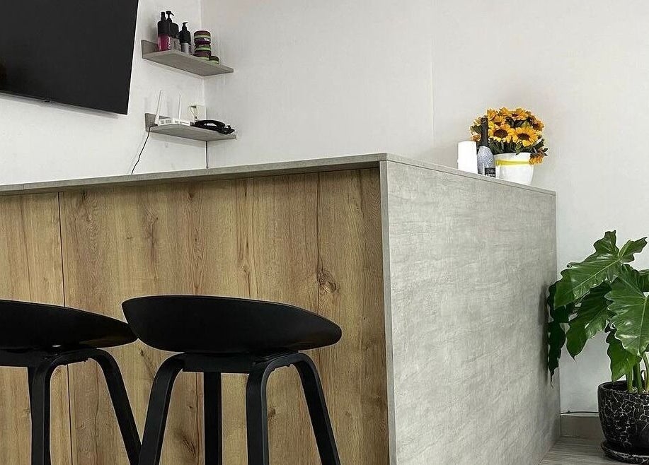 Recepción moderna en Melo Barber Studio San Luis, San Luis, Provincia De Lima, PE, con sillas negras y plantas.