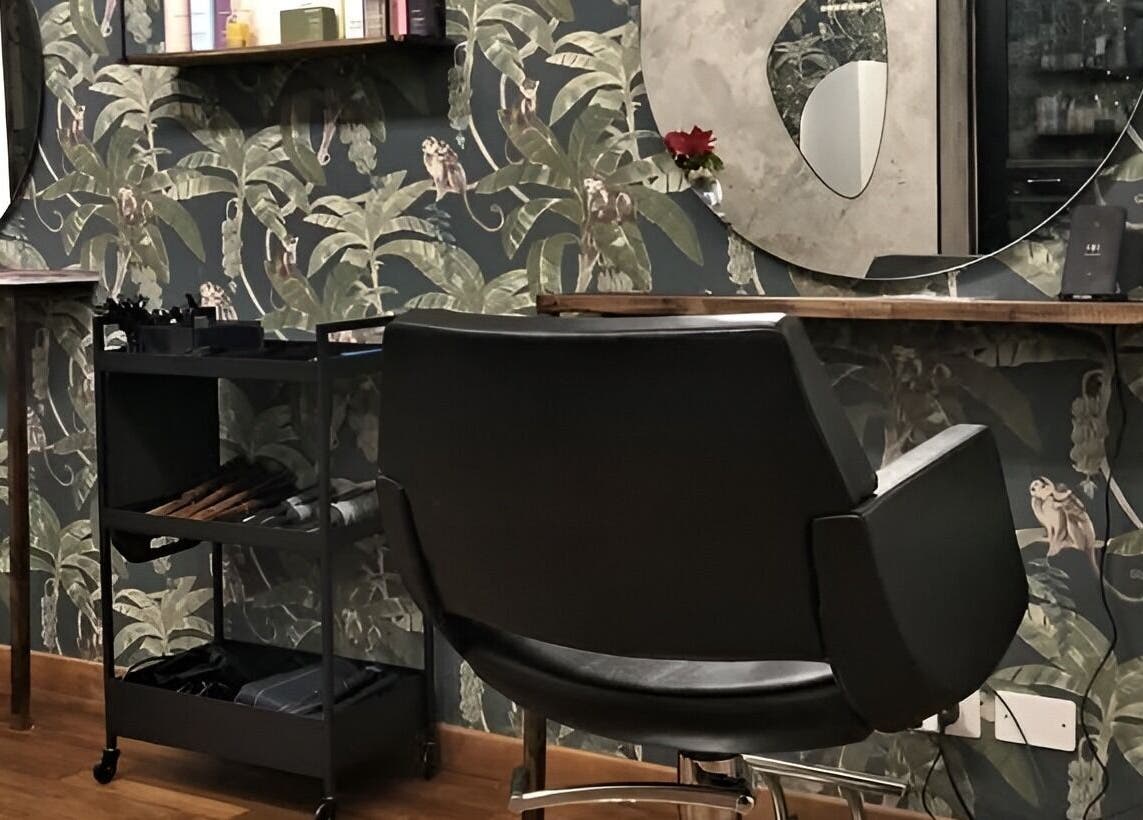 Interno di Jumies Hairsalon ad Arona, Piemonte, IT, combinando eleganza moderna e carta da parati a tema giungla.