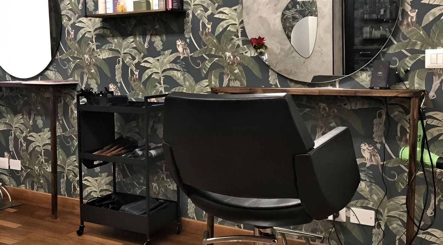 Interno di Jumies Hairsalon ad Arona, Piemonte, IT, combinando eleganza moderna e carta da parati a tema giungla.