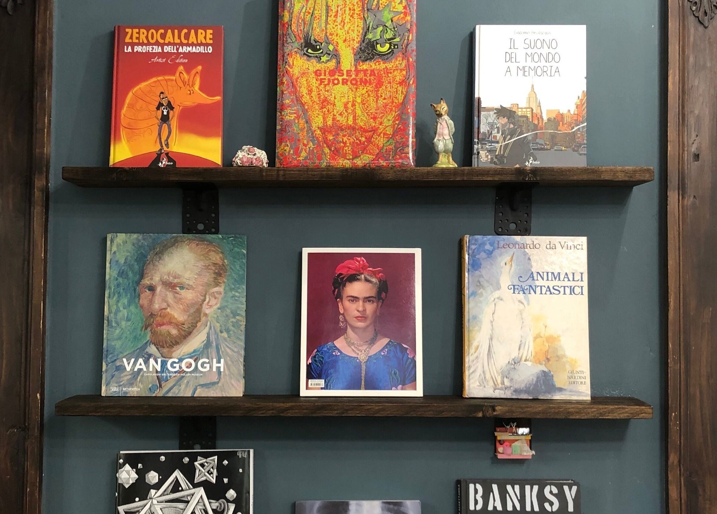 Libreria elegantemente decorata a Jumies Hairsalon, Arona, Piemonte, IT, con libri d'arte famosi.