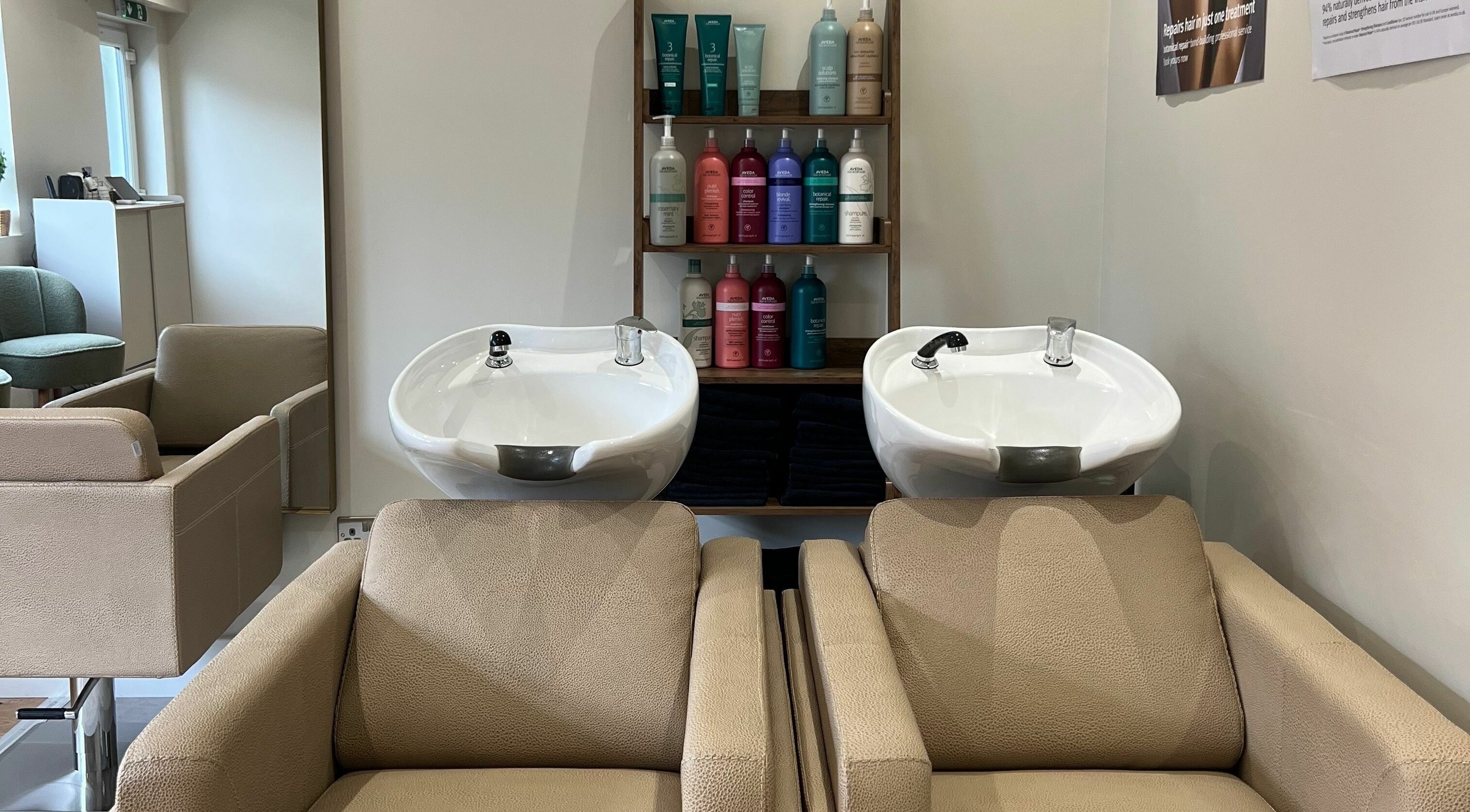 Elegant wash station at The Olive Tree Hair Salon in Brant Broughton, England featuring comfortable chairs and premium products.