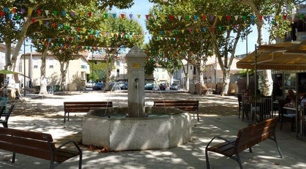Place animée près de Bulles de Bien-être, La Crau, Provence-alpes-côte D'azur, FR avec fontaine et fanions colorés.