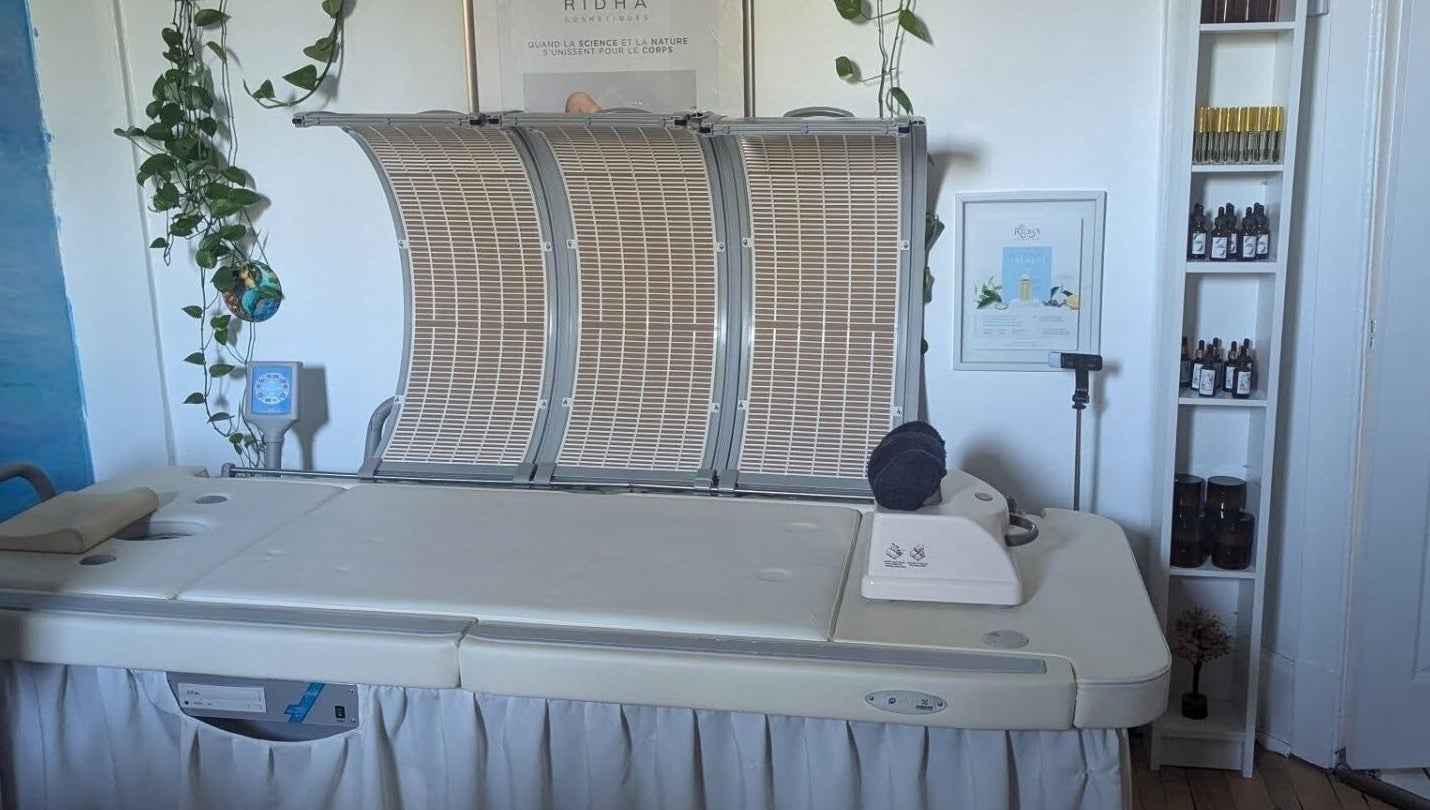 Lit de traitement moderne chez l'Alchimie de la beauté, Montréal, Québec, CA, entouré de plantes apaisantes.