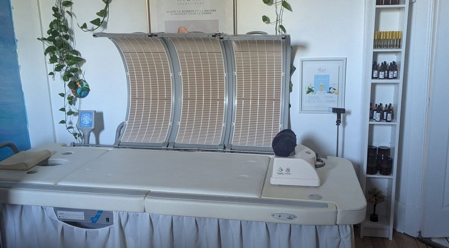 Lit de traitement moderne chez l'Alchimie de la beauté, Montréal, Québec, CA, entouré de plantes apaisantes.