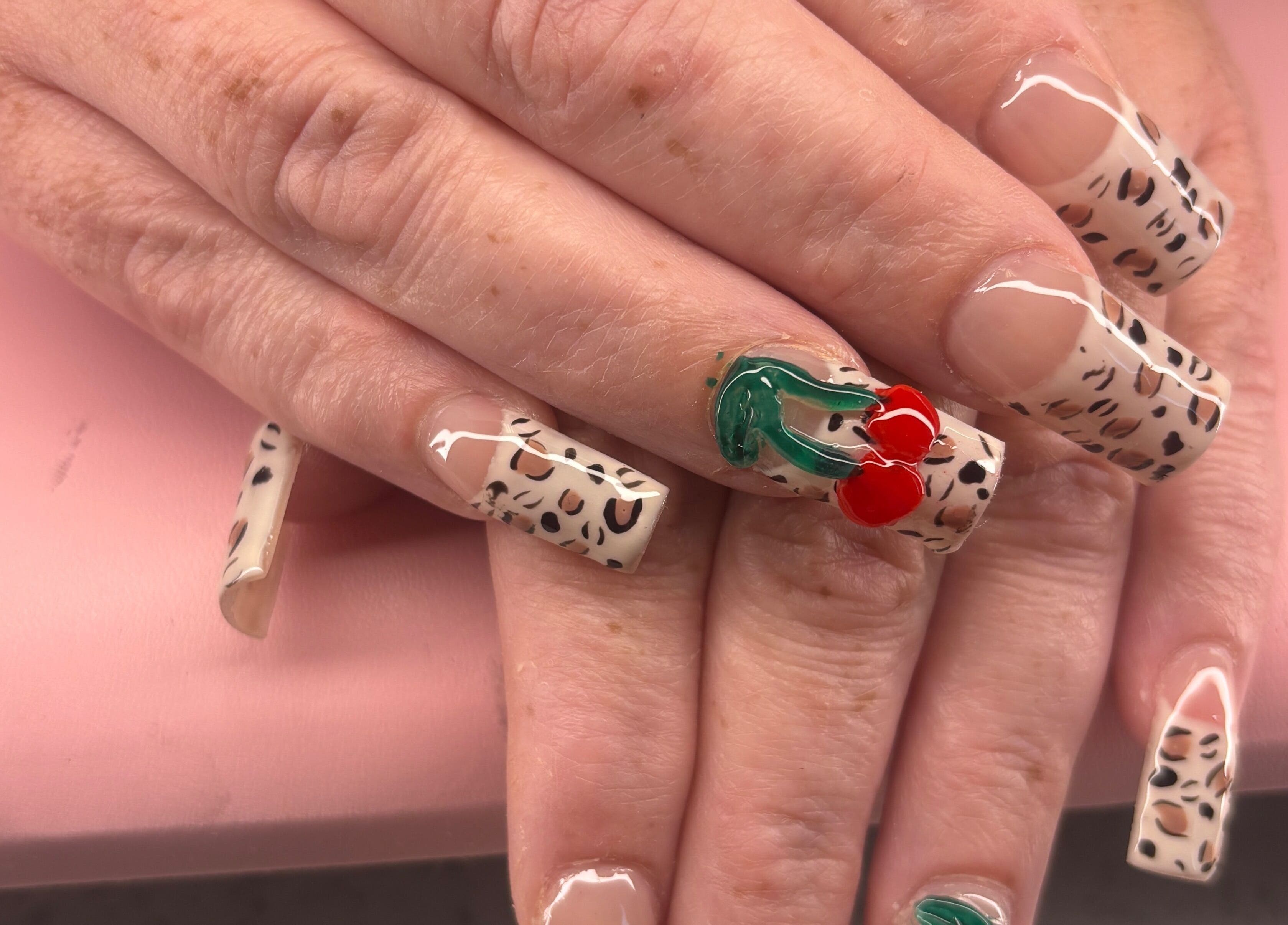 Stylish leopard print nails with cherry design at K’s NAIL BAR, Hamilton, Ontario, CA.