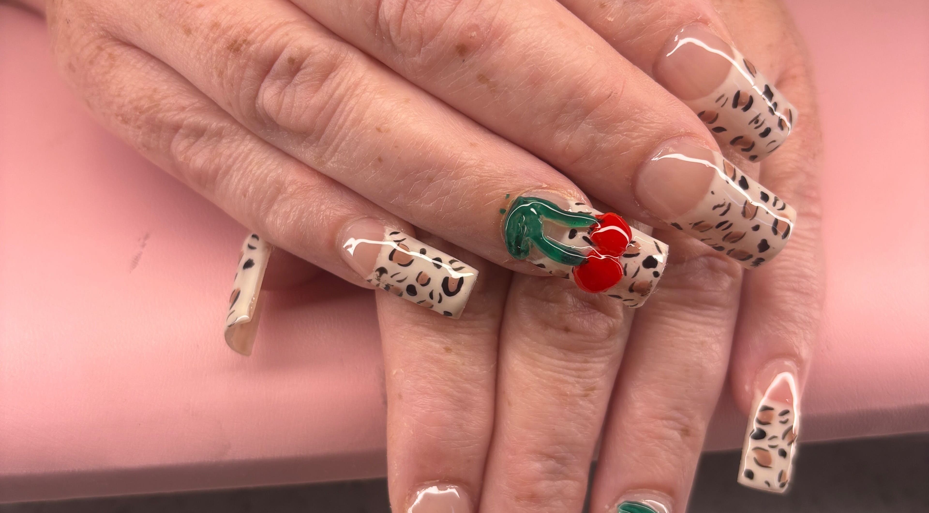 Stylish leopard print nails with cherry design at K’s NAIL BAR, Hamilton, Ontario, CA.