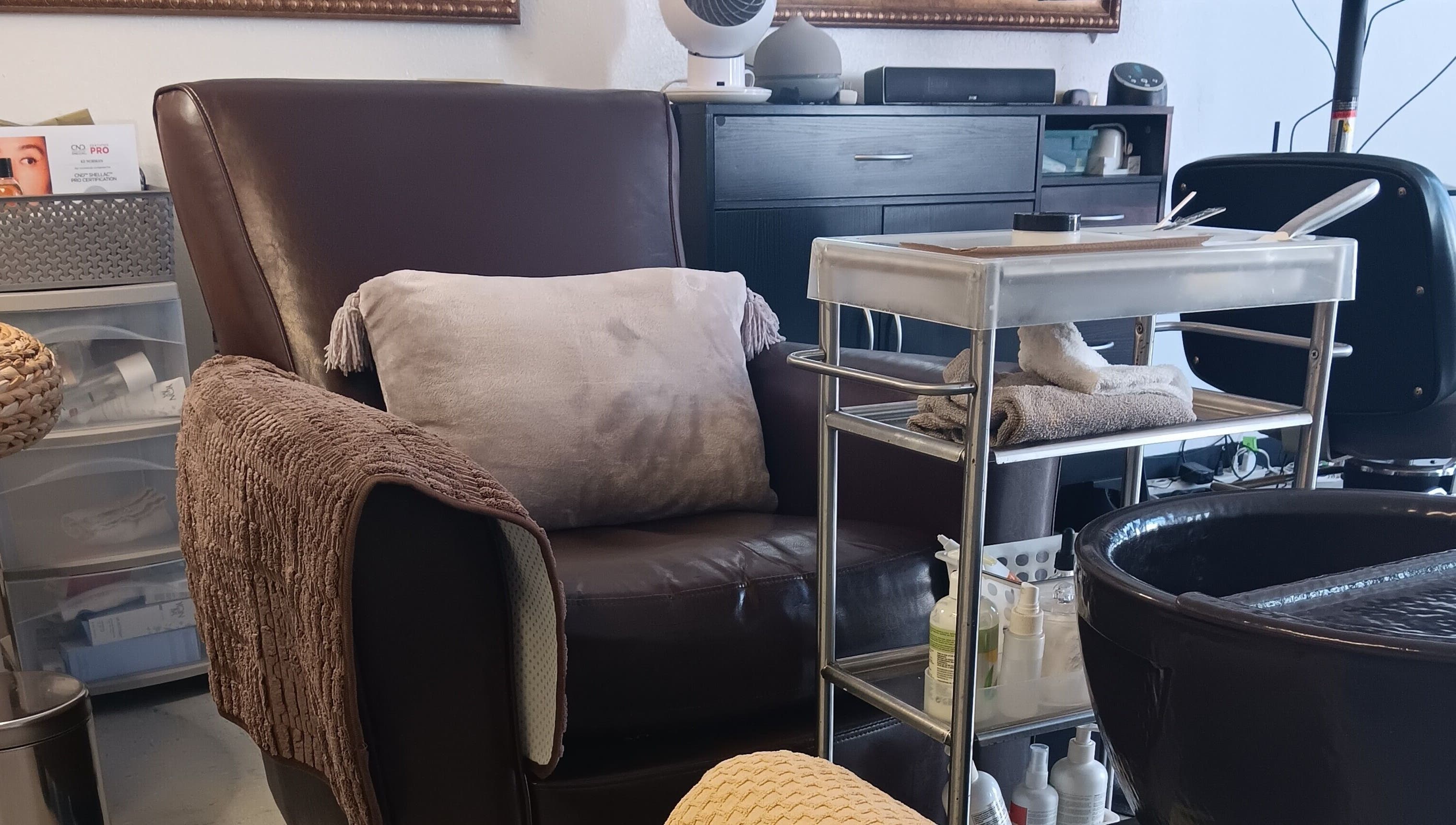 Cozy nail care station at Ke's Nail Care in Oakland, California, US with plush seating and neat organization.