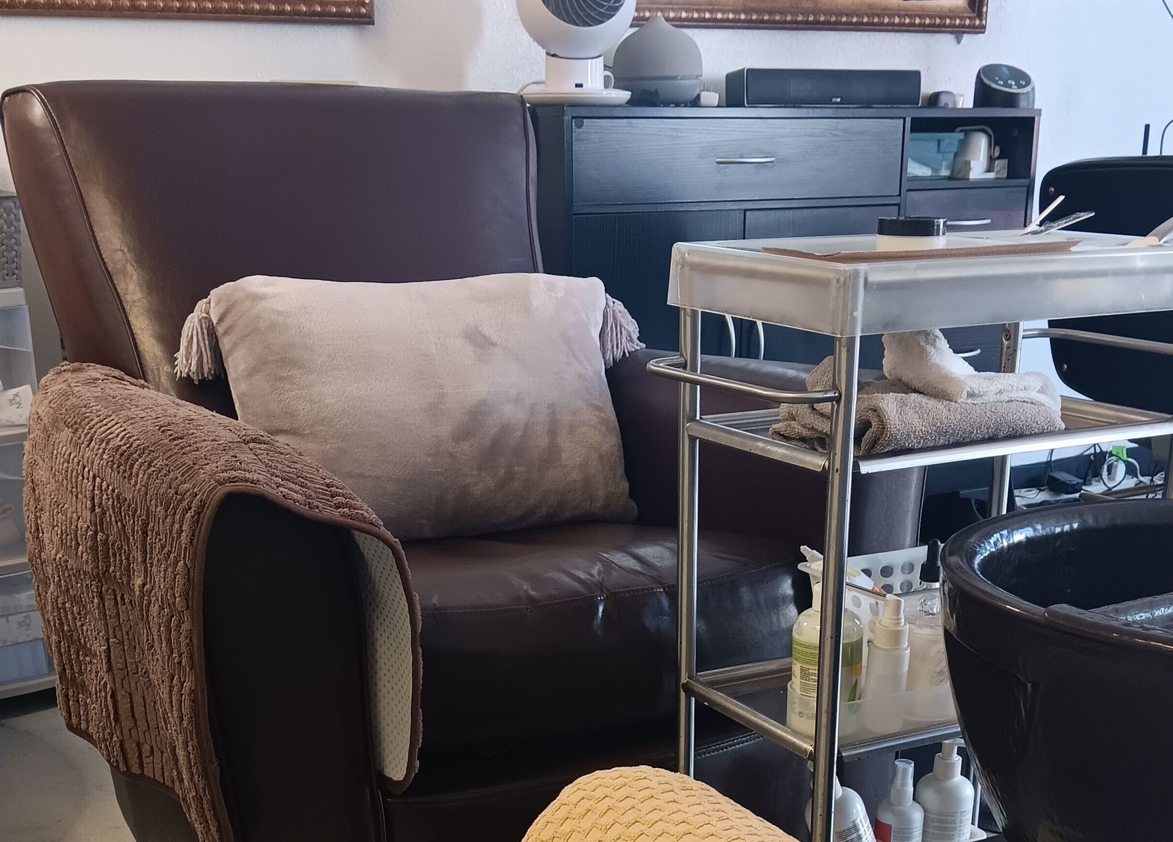 Cozy nail care station at Ke's Nail Care in Oakland, California, US with plush seating and neat organization.