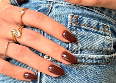 Stylish brown manicured nails at GELuxe Nail Studio, Dapto, New South Wales, AU, with gold rings.