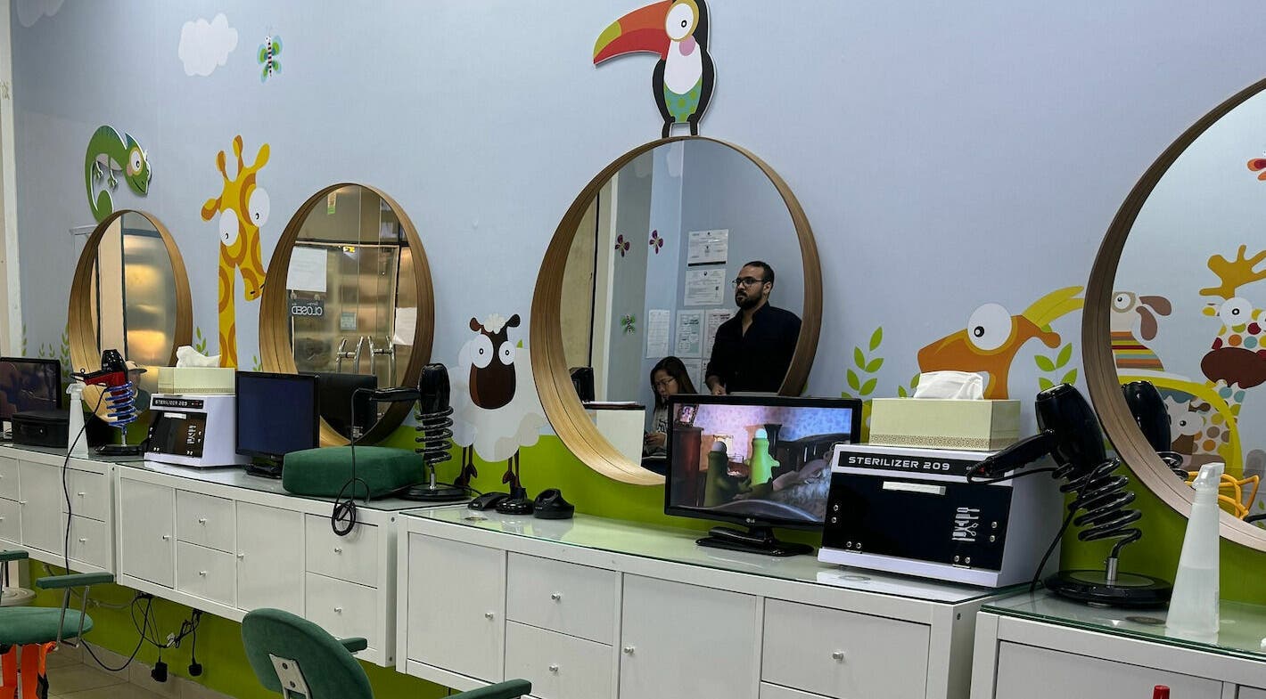 Bright and playful decor at White Sheep Kids Salon in Abu Dhabi, AE with colorful animal designs on the walls.