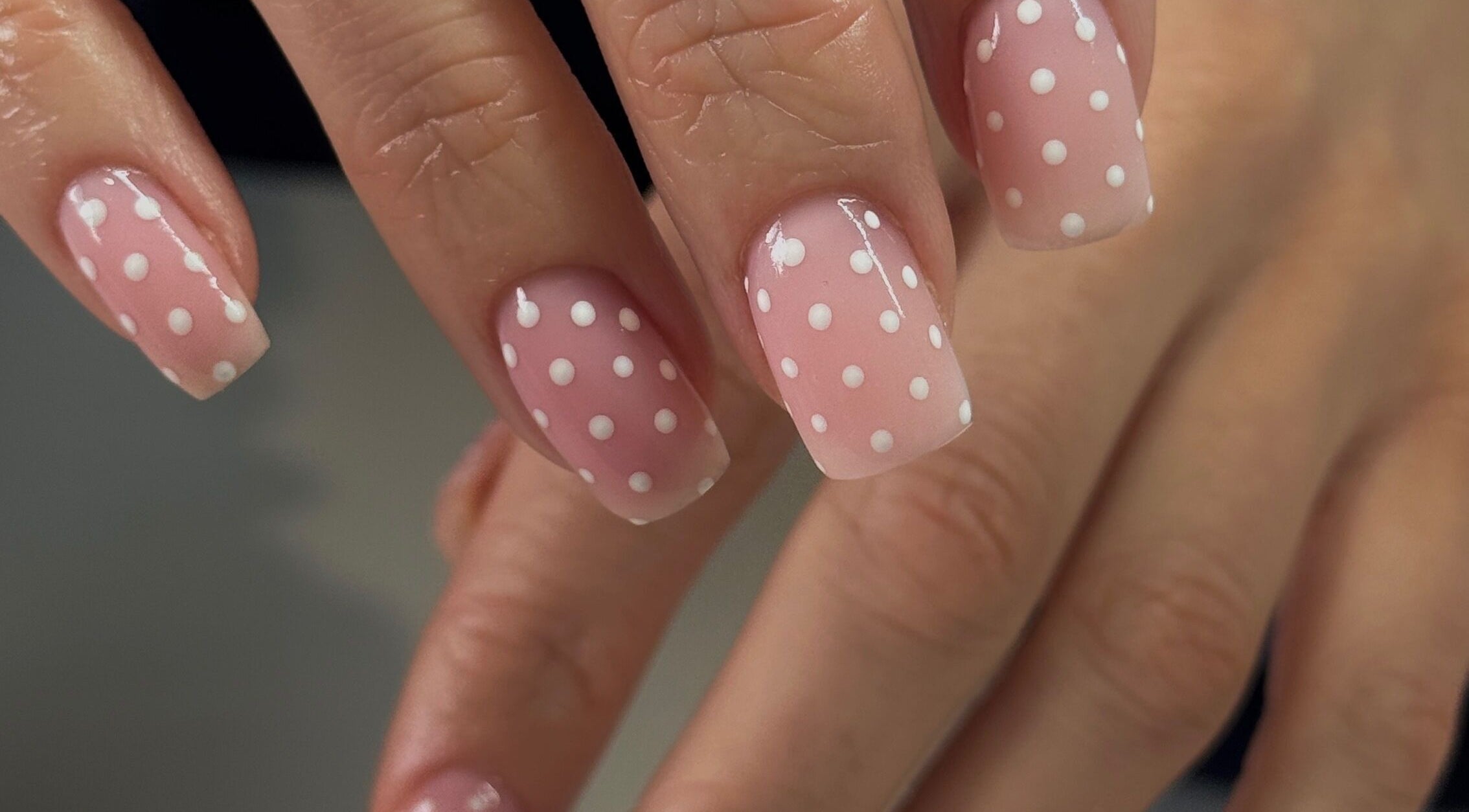 Polka dot nail art at Gel Serenity in Advancetown, Queensland, AU. Perfectly manicured hands display stylish design.