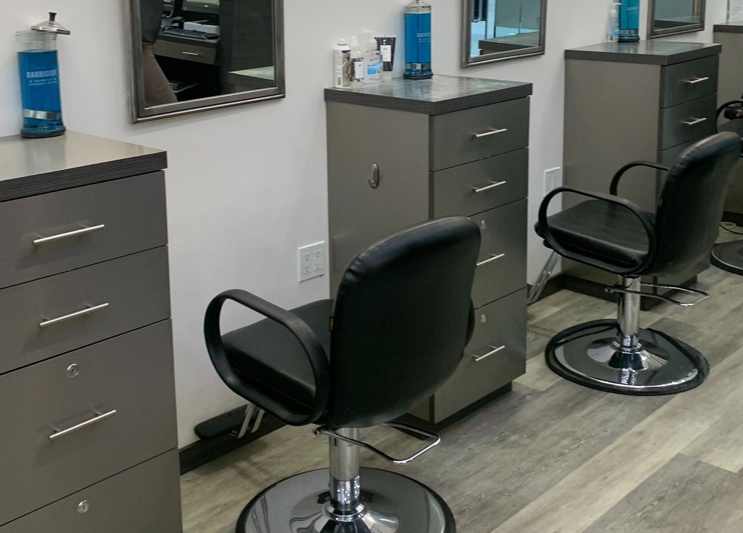 Modern styling stations at Jeffrey Stein Salon, New York, New York, US, featuring sleek black chairs.