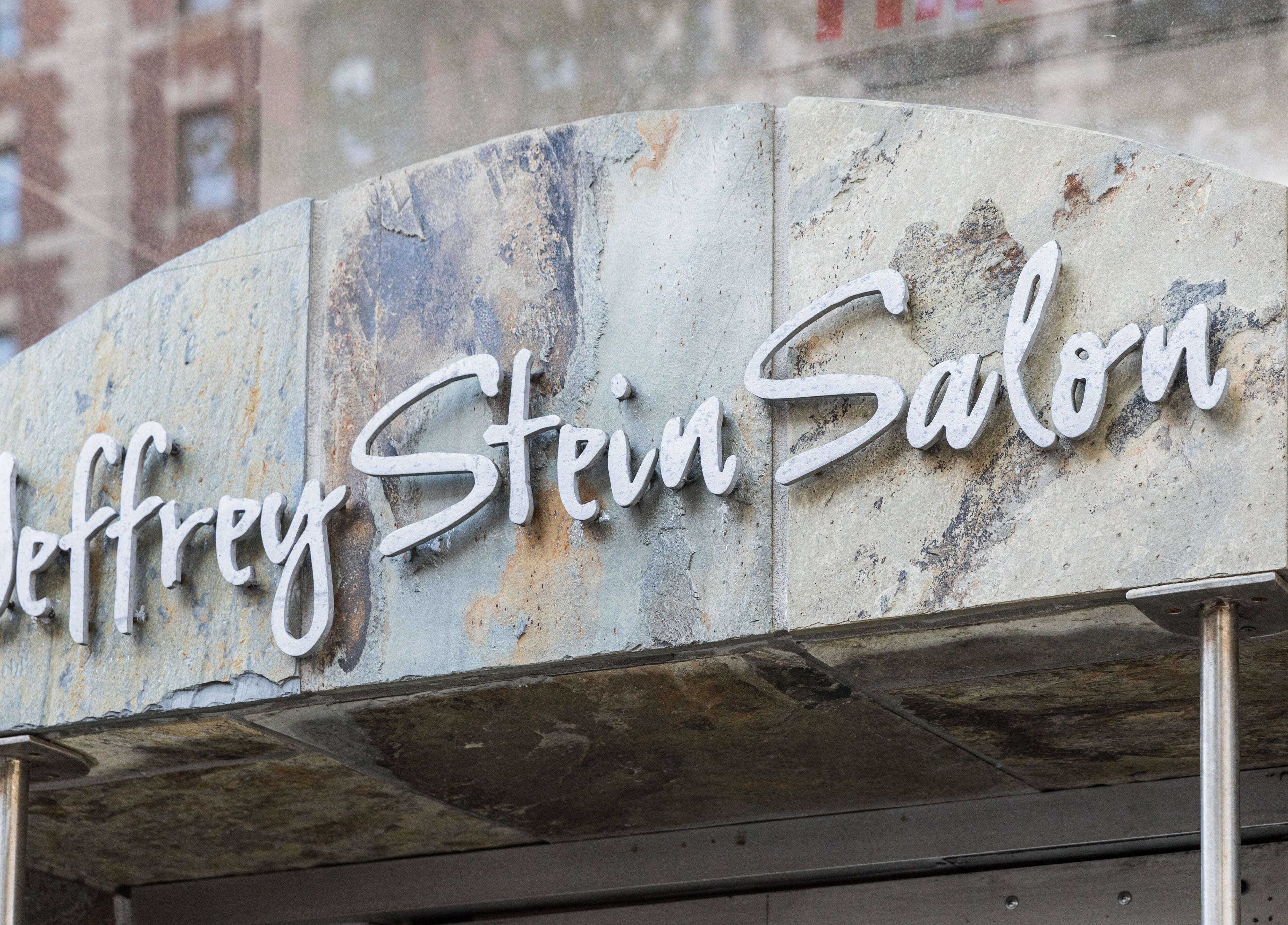 Front signage of Jeffrey Stein Salon located in New York, New York, US with a rustic stone backdrop.