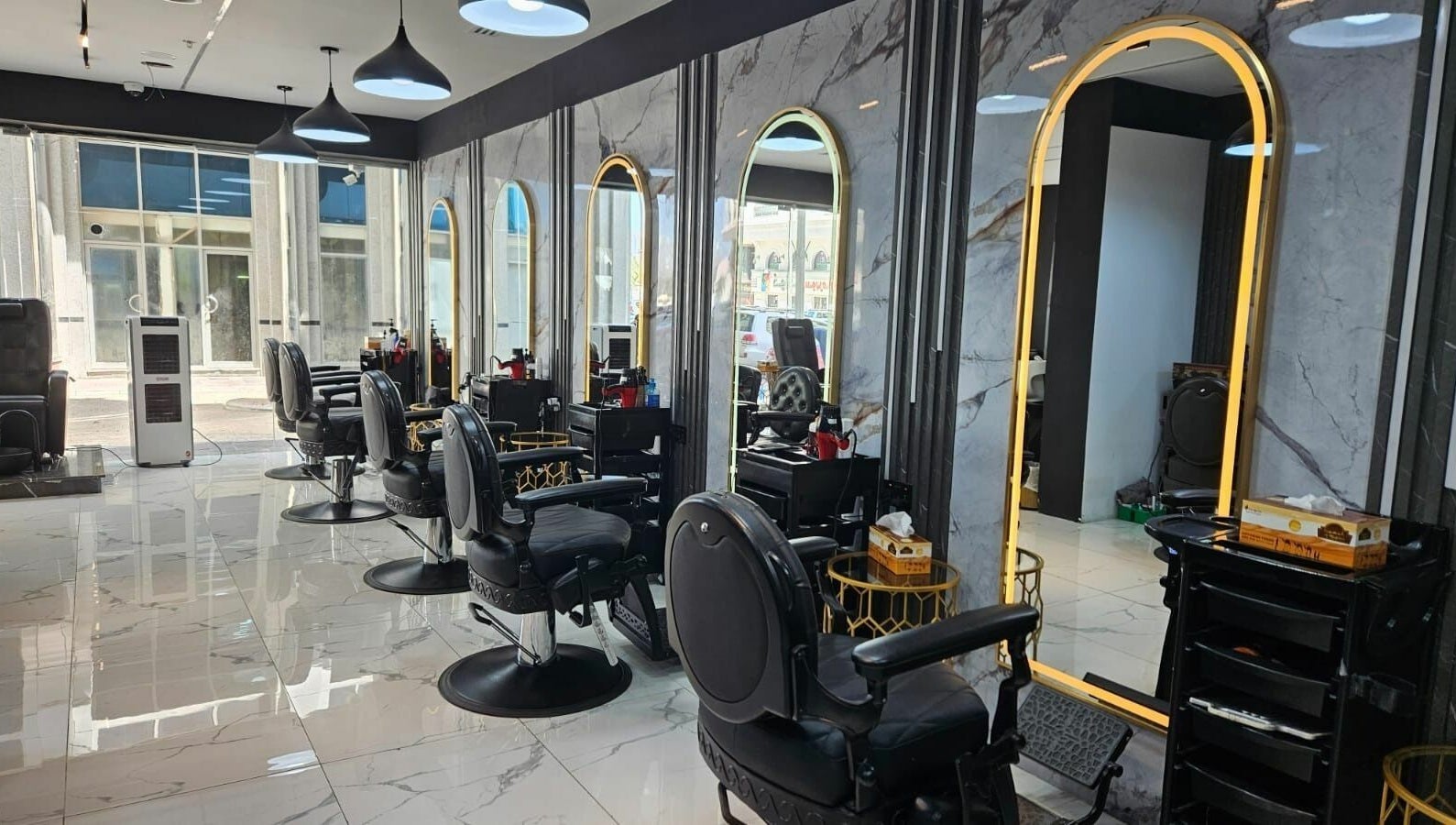 Modern interior of San Giorgio Gents Salon in أبو ظبي, أبو ظبي, AE with sleek black chairs and illuminated mirrors.