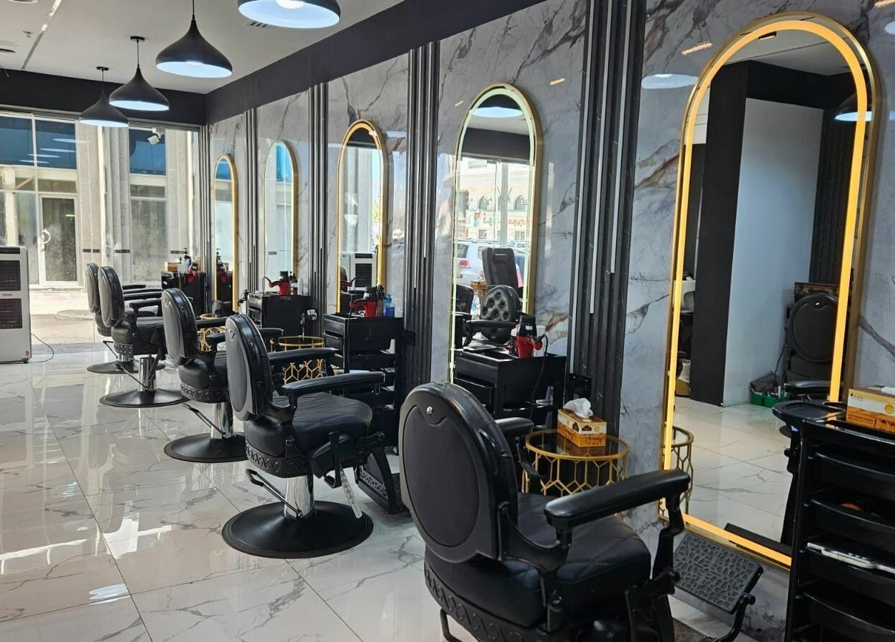 Modern interior of San Giorgio Gents Salon in أبو ظبي, أبو ظبي, AE with sleek black chairs and illuminated mirrors.