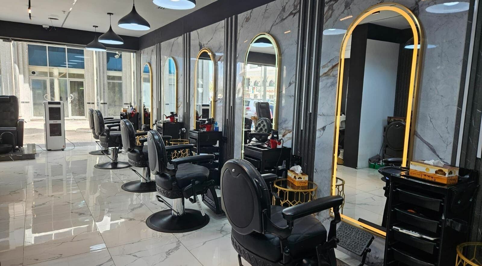 Modern interior of San Giorgio Gents Salon in أبو ظبي, أبو ظبي, AE with sleek black chairs and illuminated mirrors.
