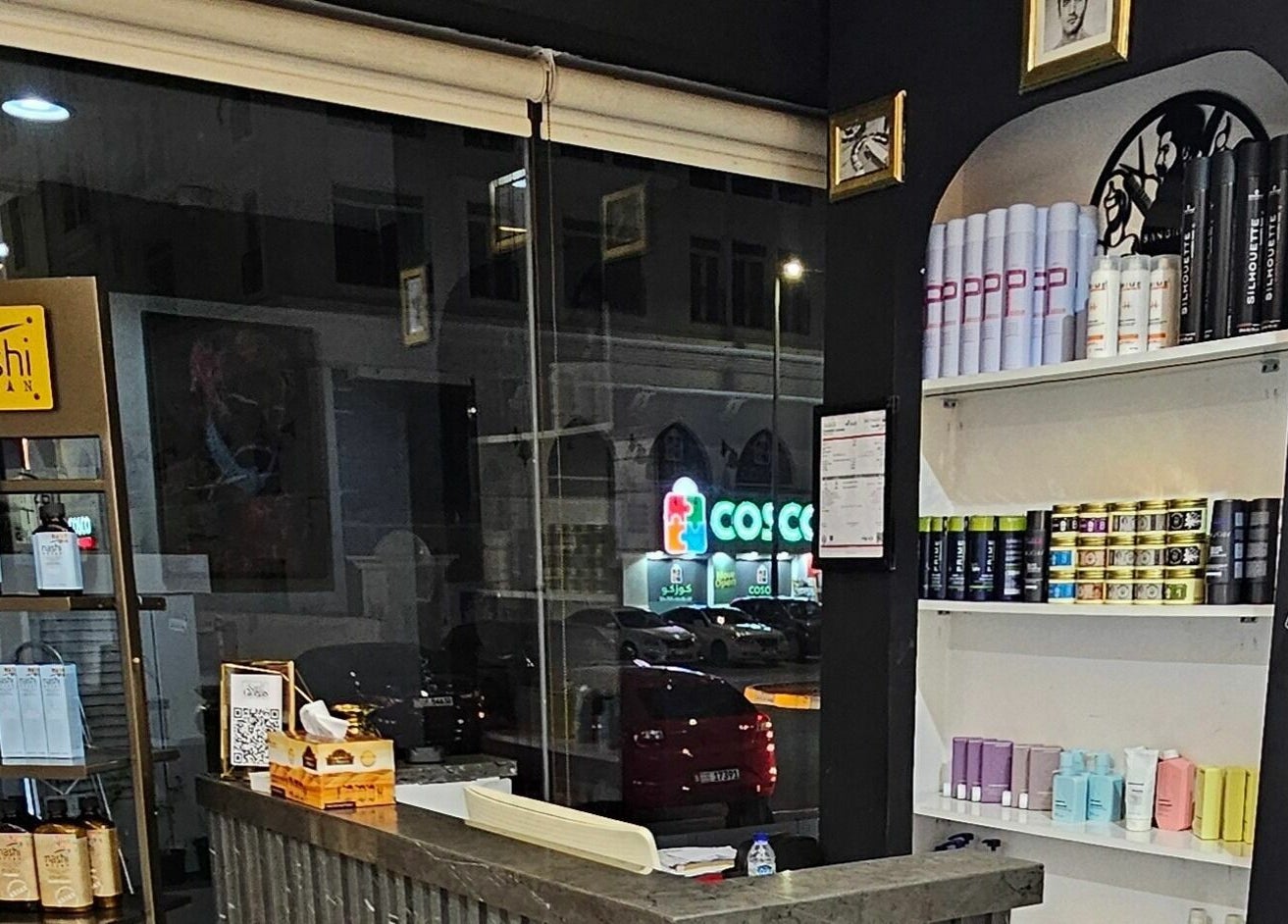Interior view of San Giorgio Gents Salon in أبو ظبي, showcasing premium hair care products on display shelves.