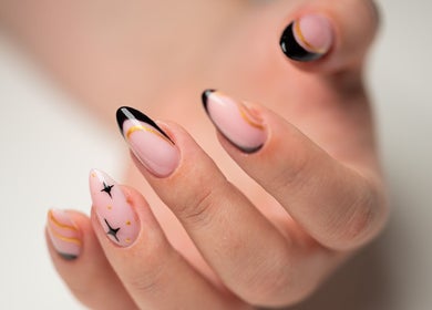Elegant black and nude nail art with gold accents at Dia Nailed It, Hove, England, GB.