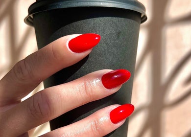 Vibrant red nails holding a cup at Dia Nailed It, Hove, England, GB, showcasing nail artistry.