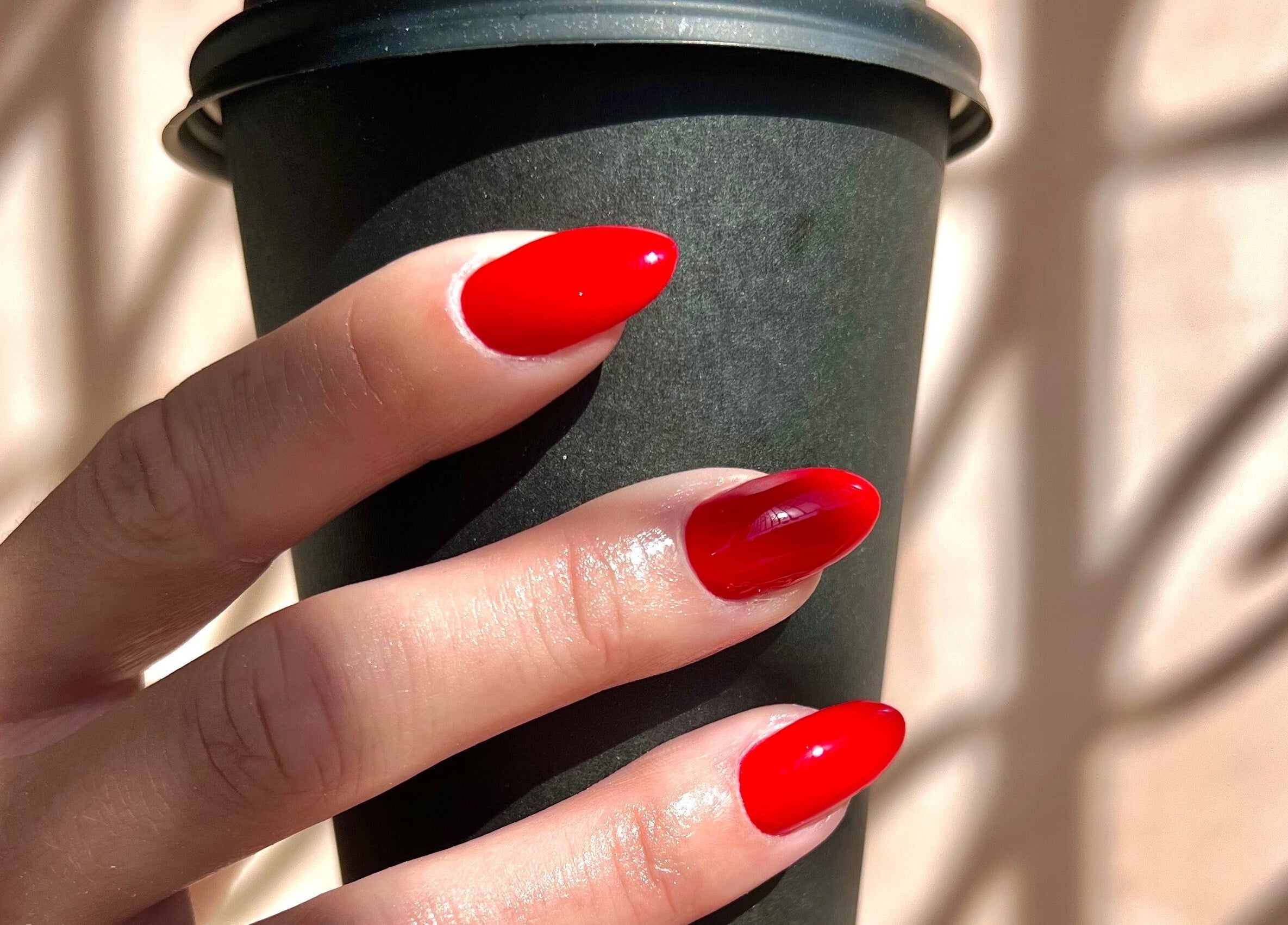 Vibrant red nails holding a cup at Dia Nailed It, Hove, England, GB, showcasing nail artistry.