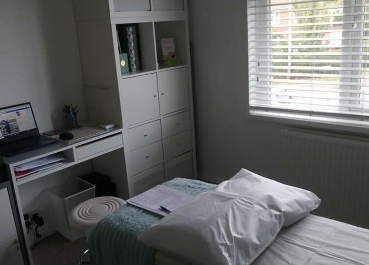 Cozy therapy room at Allfit Holistics, Fareham, England, GB, with massage bed and organized desk.