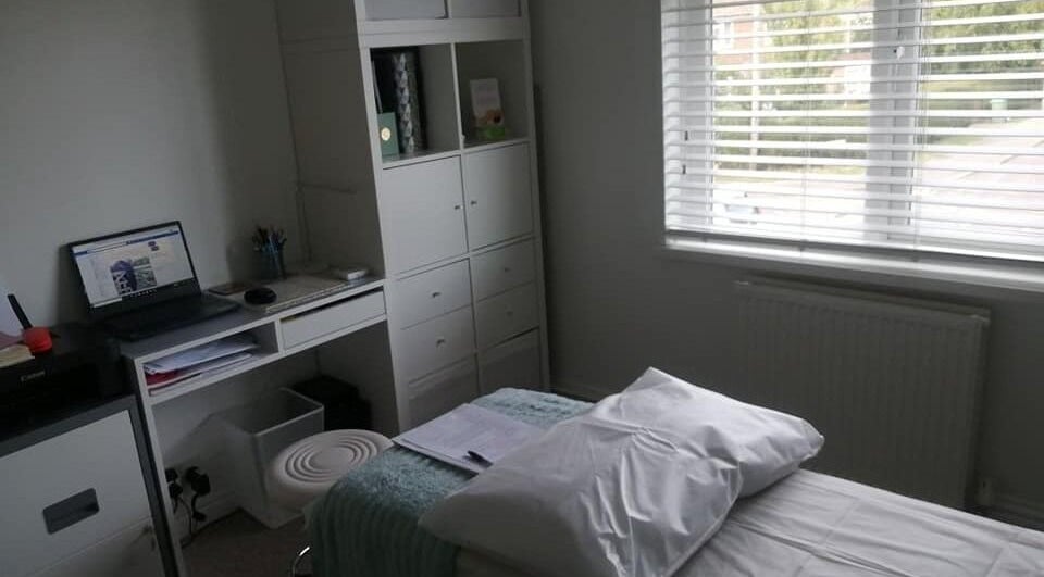 Cozy therapy room at Allfit Holistics, Fareham, England, GB, with massage bed and organized desk.