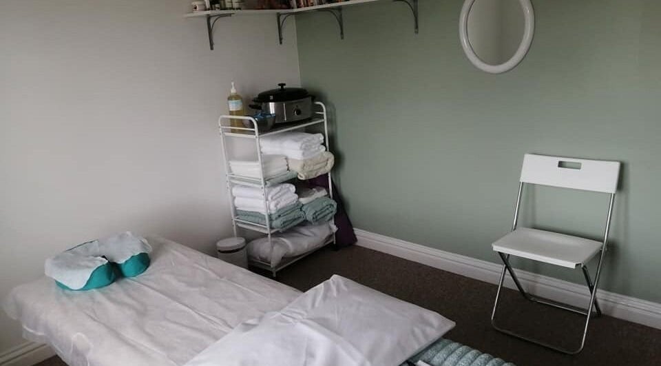 Peaceful therapy room at Allfit Holistics with massage bed, chair, and towels in Fareham, England, GB.