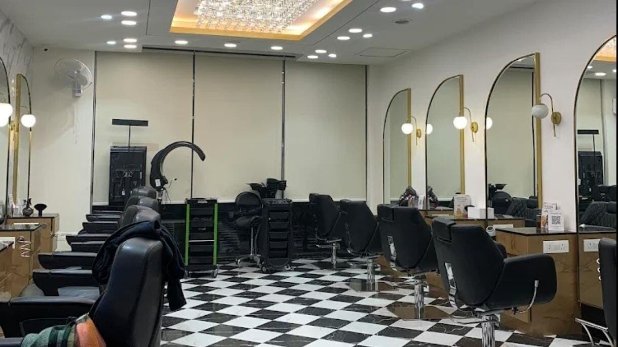 Modern salon interior at Curl Care @ Noida, featuring stylish black chairs and mirrors. Noida, Uttar Pradesh, IN.