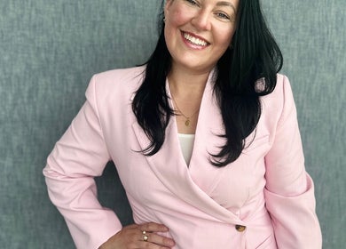 Smiling individual in a pink blazer at BCM Aesthetics, London, England, GB.