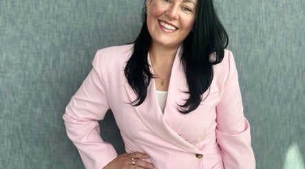 Smiling individual in a pink blazer at BCM Aesthetics, London, England, GB.