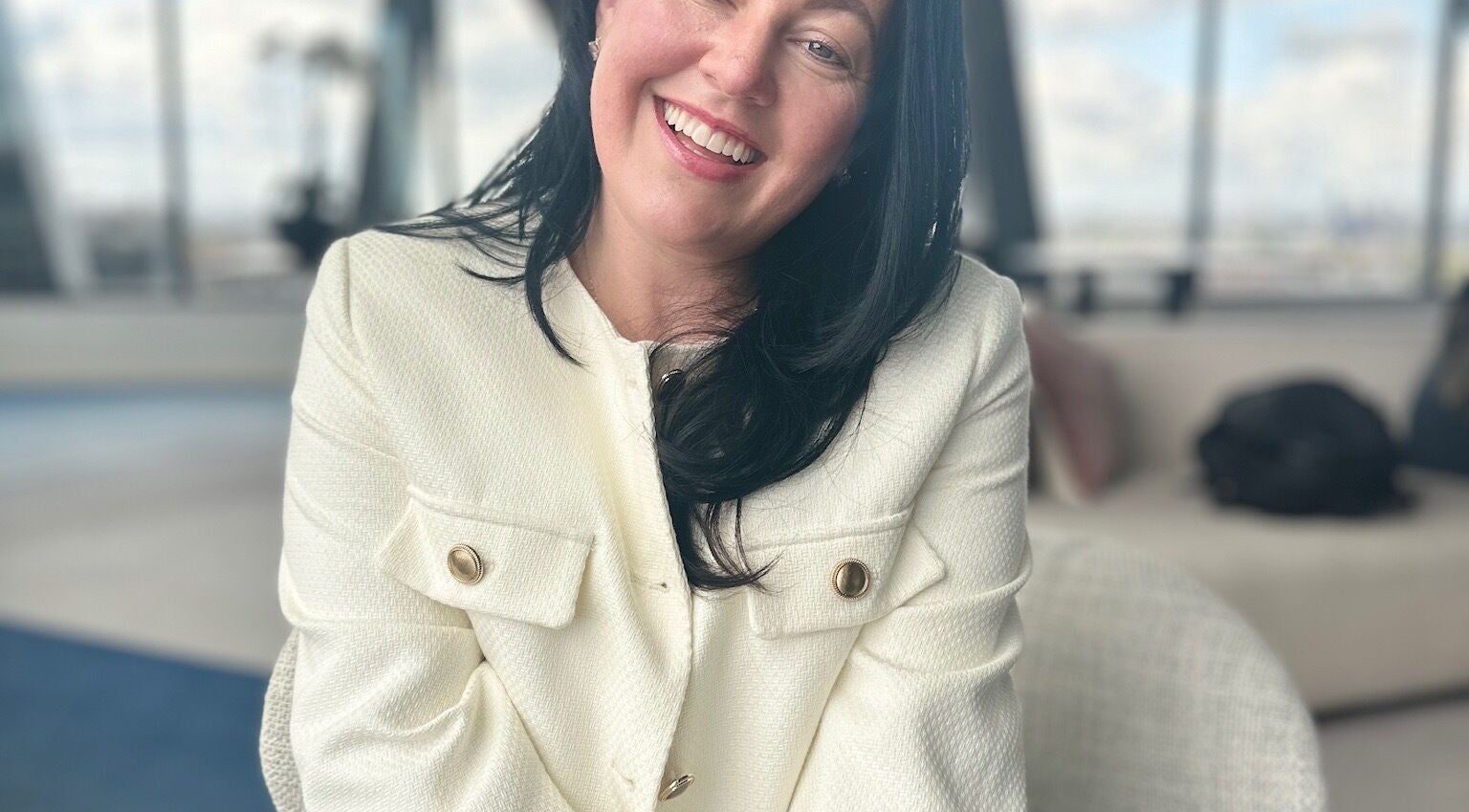 Smiling woman in elegant attire at LymphLondon by Bruna Milioli | Home Service, London, England, GB.