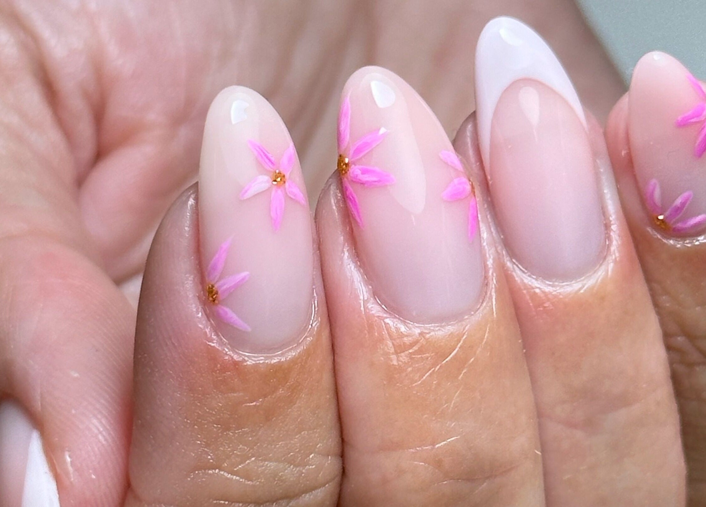 Pink floral nail art at AP Beauty MK, Towcester, England, GB. Close view of elegant manicure.