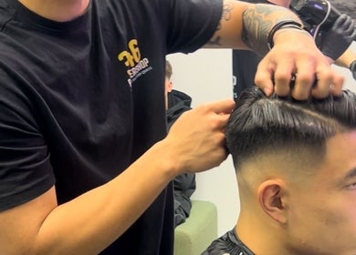 Barber styling a haircut at 346 Barbershop - Oxford Road - Manchester City Centre, Manchester, England, GB.