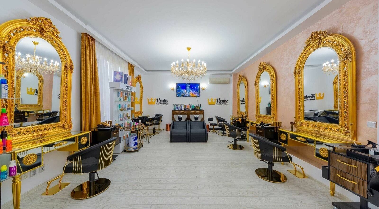 Interior luxos al salonului Hentz Beauty Concept din Voluntari, Județul Ilfov, RO, cu oglinzi aurii și candelabru elegant.