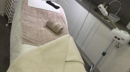 Relaxing treatment room at Brows & Graces, Monifieth, Scotland, GB with a massage table and equipment.