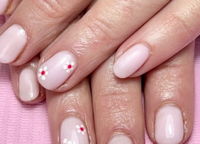 Elegant floral nail art at Glam Body in Penrith, New South Wales, AU. Soft pink polish with delicate flower designs.
