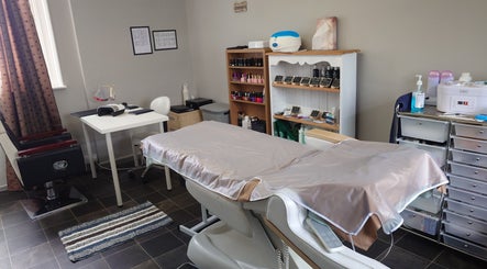 Tranquil therapy room at By Lily Beauty And Hair in Dereham, England, GB with a treatment bed and nail station.