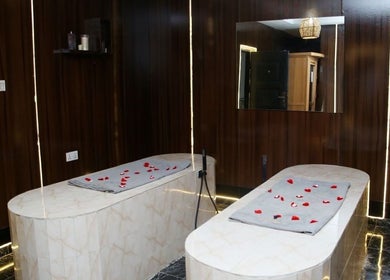 Luxurious spa room at Marvels Aesthetics Abuja, Abuja, Federal Capital Territory, NG with rose petals on massage tables.