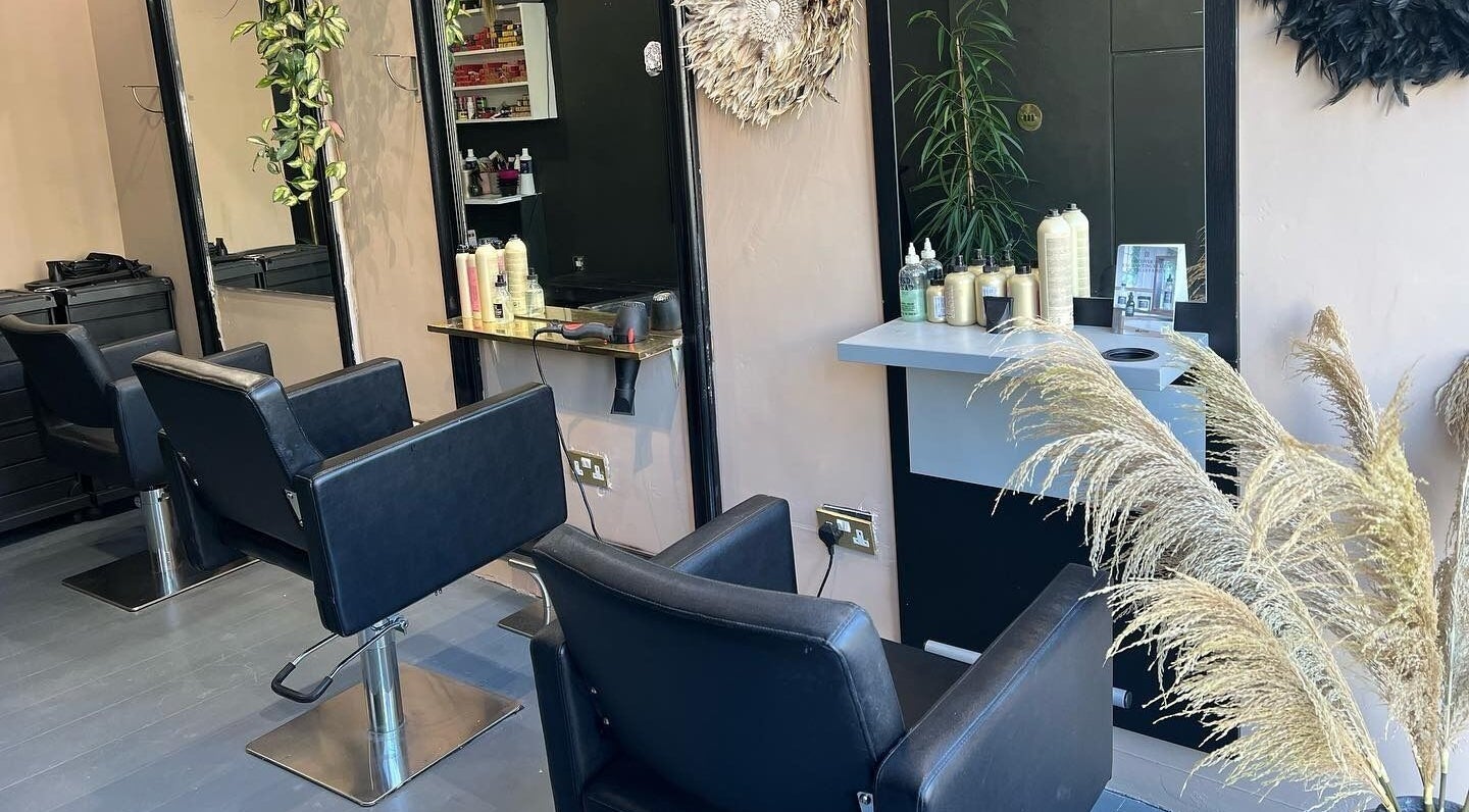 Beats Hair Salon in London, England, GB. Modern interior with black chairs, mirrors, and styling products.